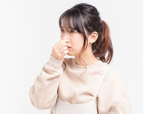 鼻をつまむ女性