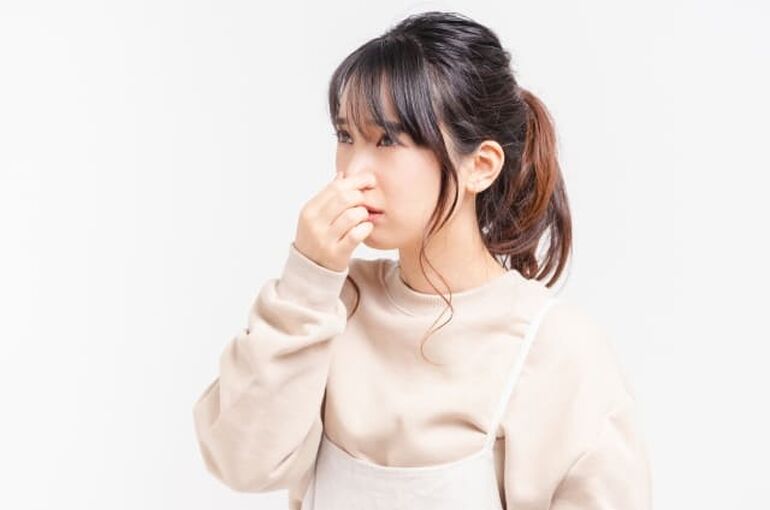 鼻をつまむ女性